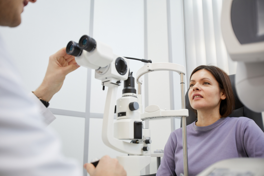 Portrait,Of,Young,Woman,Looking,At,Refractometer,Machine,During,Vision